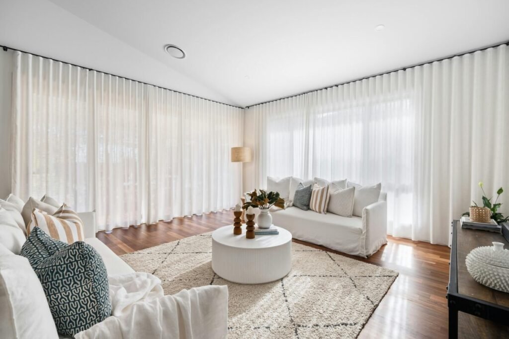 Cortinas leves permitindo entrada de luz natural na sala